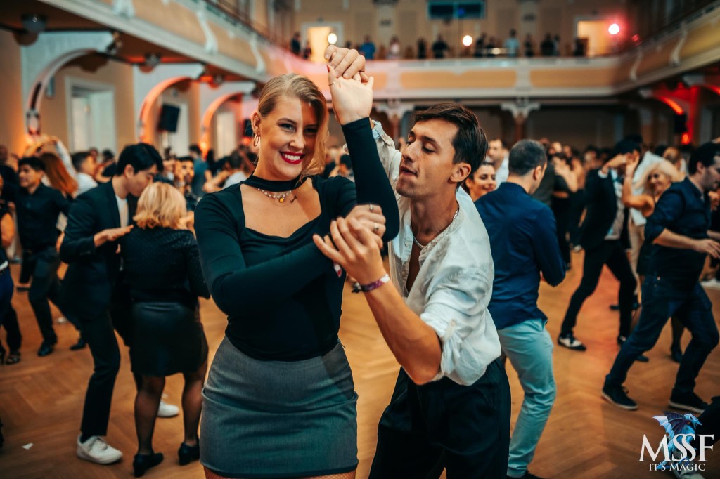 Ένα ζευγάρι χορεύει salsa σε γεμάτη social πίστα
